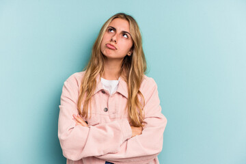 Young caucasian blonde woman isolated on blue background  tired of a repetitive task.