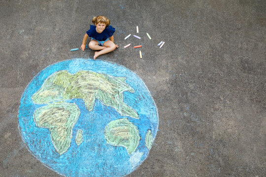 Little preschool girl with earth globe painting with colorful chalks on ground. Positive toddler child. Happy earth day concept. Creation of children for saving world, environment and ecology. - Powered by Adobe