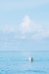 Alone lady surfer in the water waiting for the wave