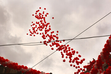 Low angle shot of many red balloons getting released to the air