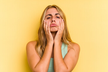 Young caucasian blonde woman isolated on yellow background  whining and crying disconsolately.