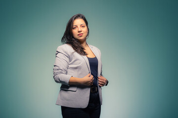 Business brunette woman adjusting her clothes on a blue background