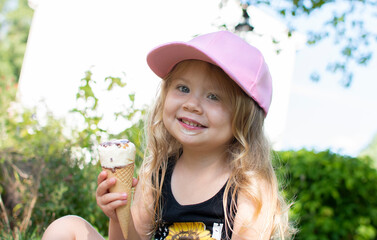 Little girl eating ice cream in the park. happy child eating ice cream