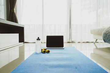 Fitness sports equipment and laptop in living room, Fitness online training concept. 
