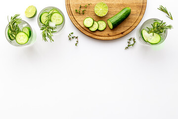 Fresh cold drink with cucumber lime and herbs in glasses