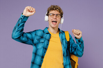 Young fun boy teen student in casual clothes backpack headphones glasses listen to music isolated on plain pastel light violet background studio. Education in high school university college concept.