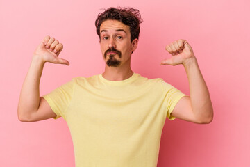 Young caucasian man isolated on pink background feels proud and self confident, example to follow.