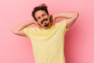 Young caucasian man isolated on pink background stretching arms, relaxed position.