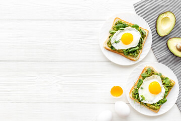 Open sandwich with avocado spinach cream and eggs. Top view