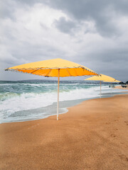 Yellow beach umbrellas on the sand. Storm.