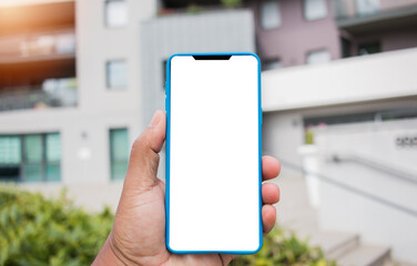 Man's hand using cellphone outdoor, Man typing text message on smart phone blurred city background