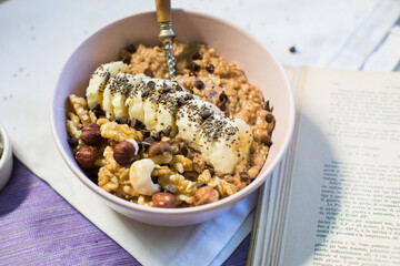 Bowl of oatmeal porridge with banana and nuts. Top view. Healthy vegan breakfast