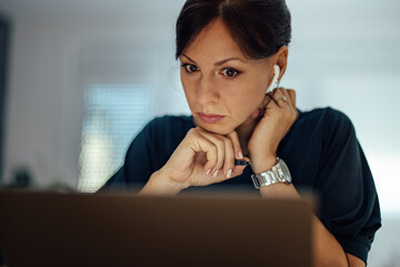 Close-up portrait of a female manager looking at laptop.