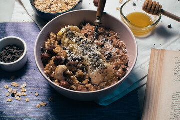 Bowl of oatmeal porridge with banana and nuts. Top view. Healthy vegan breakfast
