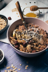 Bowl of oatmeal porridge with banana and nuts. Top view. Healthy vegan breakfast