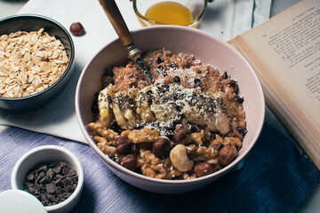 Bowl of oatmeal porridge with banana and nuts. Top view. Healthy vegan breakfast