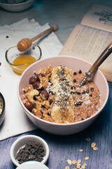 Bowl of oatmeal porridge with banana and nuts. Top view. Healthy vegan breakfast