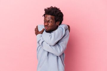 Young african american man isolated on pink background hugs, smiling carefree and happy.