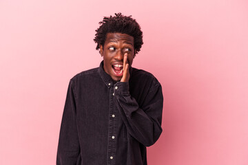 Young african american man isolated on pink background shouting excited to front.