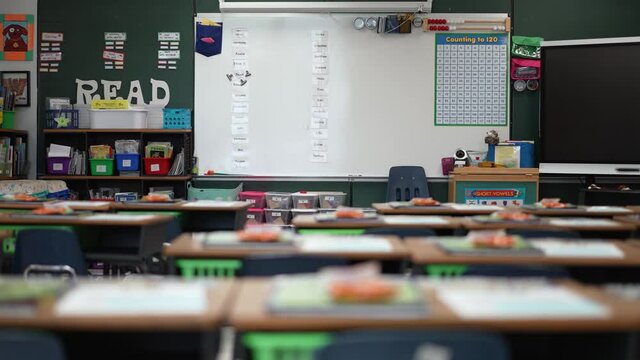 Camera slide to left showing empty school classroom with interactive whiteboard no people during pandemic.