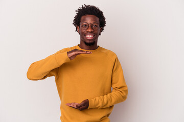 Obraz premium Young african american man isolated on white background holding something with both hands, product presentation.