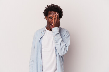 Young african american man isolated on white background  having fun covering half of face with palm.
