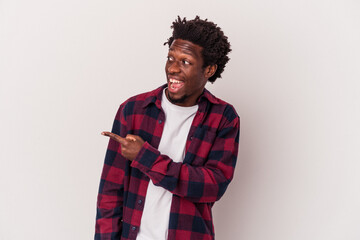 Fototapeta premium Young african american man isolated on white background looks aside smiling, cheerful and pleasant.