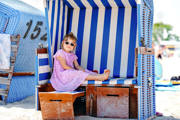Little preschool girl resting on beach chair. Cute happy toddler child on family vacations on the...