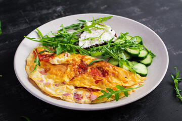 Breakfast. Omelette with tomatoes, cheese  and salad on white plate.  Frittata - italian omelet.