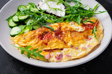 Breakfast. Omelette with tomatoes, cheese  and salad on white plate.  Frittata - italian omelet.
