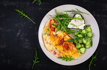 Breakfast. Omelette with tomatoes, cheese  and salad on white plate.  Frittata - italian omelet. Top view, flat lay