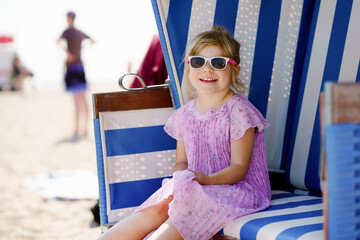 Little preschool girl resting on beach chair. Cute happy toddler child on family vacations on the...