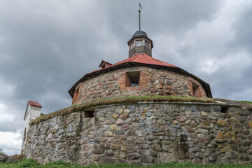 Fototapeta premium At the foot of the ancient Lars Torstensson Tower (Pugachev Tower) on a cloudy August day. Fortress Korela, Priozersk. Leningrad region, Russia
