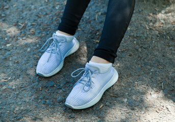 Fashionable woman in sneakers shoes. In the city.