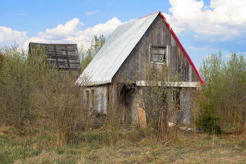 Abandoned old little house on a garden plot in May afternoon