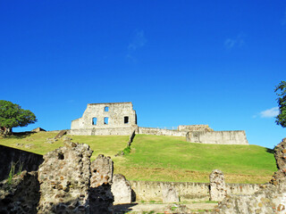 Fototapeta na wymiar Ruins of Dubuc castle with green grass and blue sky (National Heritage of France), Tartane, Martinique, French West Indies, Caribbean Sea. Colonial ruins landscape.