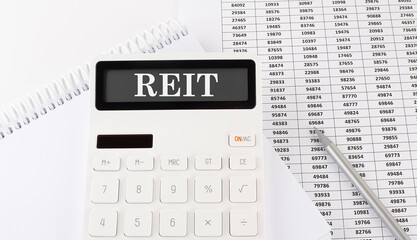 Calculator with text REIT on the notebook . Business, finance conceptual.