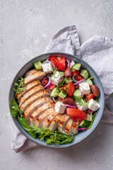 Grilled chicken breast. Fried chicken fillet and fresh vegetable salad with tomatoes, cucumber and feta cheese. Chicken meat with greek salad. Healthy food.
