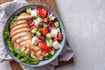 Grilled chicken breast. Fried chicken fillet and fresh vegetable salad with tomatoes, cucumber and feta cheese. Chicken meat with greek salad. Healthy food.