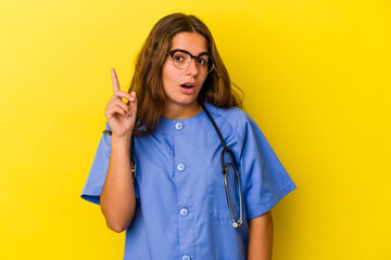 Young nurse woman isolated on yellow background  having some great idea, concept of creativity.