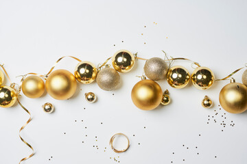 Pile of golden Christmas decorations on white background. Top view of various Xmas festive baubles on white