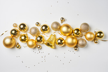 Pile of golden Christmas decorations on white background. Top view of various Xmas festive baubles on white