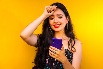 Woman talking on her cell phone on a yellow wall