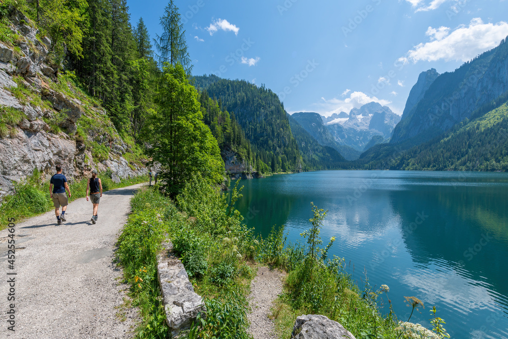 Wall mural gosausee, austria; july 31, 2021 - people hiking at gosausee, a beautiful lake with moutains in salz