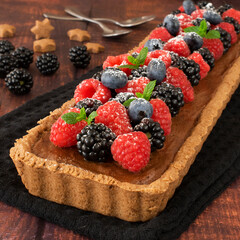 Tart with chocolate mousse, raspberry jam and forest fruit.
