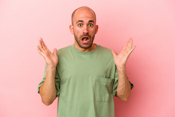 Naklejka premium Young caucasian bald man isolated on pink background screaming to the sky, looking up, frustrated.