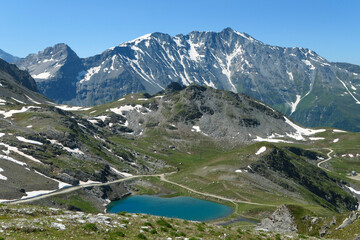 Lake in mountain. Mountainous valley in summer with green pastures.