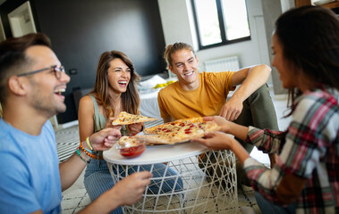 Spending time with friends. Group of cheerful young people talking and eating pizza together