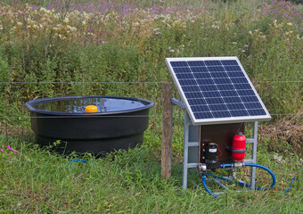 Modern agriculture: solar panel providing energy for cattle drinking water and electric fence