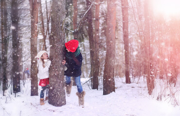 A winter fairy tale, a young mother and her daughter ride a sled in the forest. A girl on a sled with gifts on the eve of the new year in the park. 